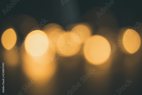 Blurred focus of circular bokeh lights in warm golden tone for abstract background. Seasons greetings, Merry Christmas and Happy New Year celebrations concept.