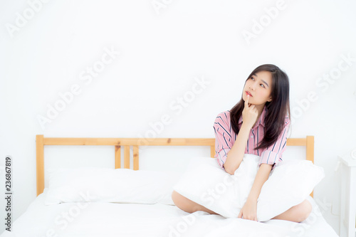 Beautiful portrait young asian woman smile confident thinking while wake up in the bedroom, girl sitting expression serious or doubts with idea, lifestyle and relax concept.