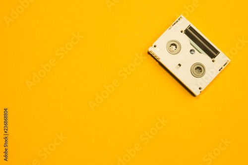 Digital video cassette on yellow background. mini cassette. copy space photo