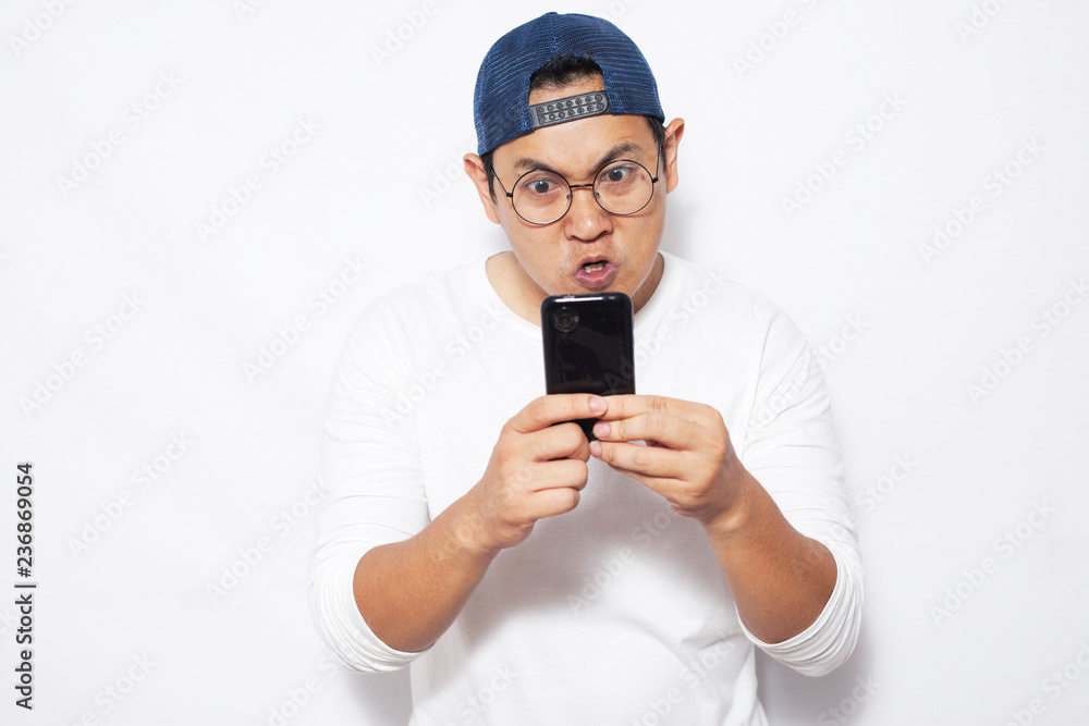 Young Man Texting Reading Chatting on His Phone, Angry Expression Young Man Texting Reading Chatting on His Phone, Angry Expression