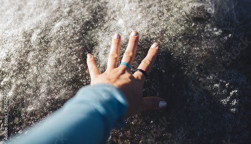 Woman's hand feels ice/rocks