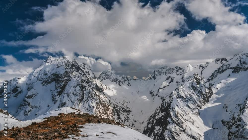 time laps video of beautiful snowy peaks with running clouds on a Sunny day. Clouds fly over mountain snow slopes in a blue sky. time laps video of beautiful snowy peaks with running clouds on a Sunny day. Clouds fly over mountain snow slopes in a blue sky.