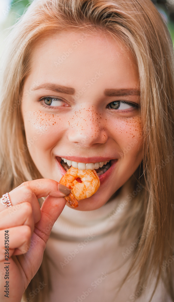 Young beautiful woman eating black pasta with seafood and cuttlefish ink in the outdoor restaurant. Funny and beautiful. Young beautiful woman eating black pasta with seafood and cuttlefish ink in the outdoor restaurant. Funny and beautiful.