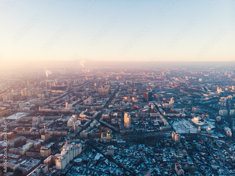 Aerial panorama of winter Voronezh city from above at sunset, many small buildings in snow, modern downtown of Russian cityscape drone view