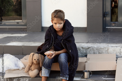 Canvas-taulu Poor little boy with bread on city street