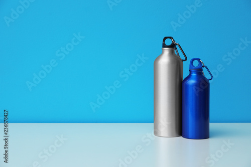 Aluminum water bottles for sports on color background. Space for text