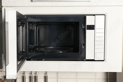 Open modern microwave oven built in kitchen furniture
