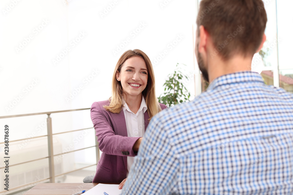 Human resources manager conducting job interview with applicant in office Human resources manager conducting job interview with applicant in office