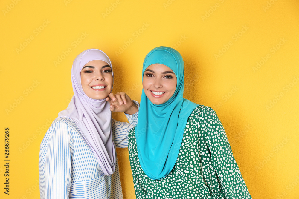 Portrait of young Muslim women in hijabs against color background Portrait of young Muslim women in hijabs against color background