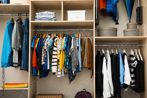 Large wardrobe with teenager clothes on hangers
