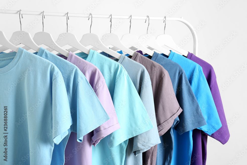 Men's clothes hanging on wardrobe rack against white background