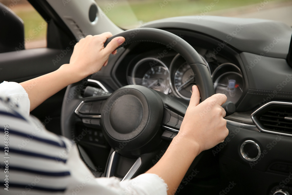 Woman holding steering wheel in car, closeup. Driving license test