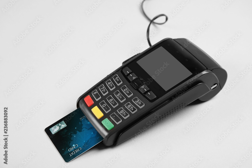 Modern payment terminal with credit card on grey background Modern payment terminal with credit card on grey background