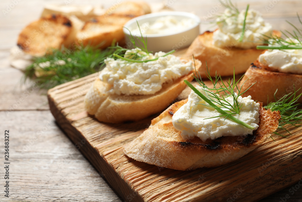 Toasted bread with tasty cream cheese on wooden board Toasted bread with tasty cream cheese on wooden board