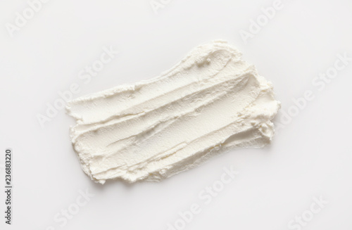 Smear of tasty cream cheese on white background, top view