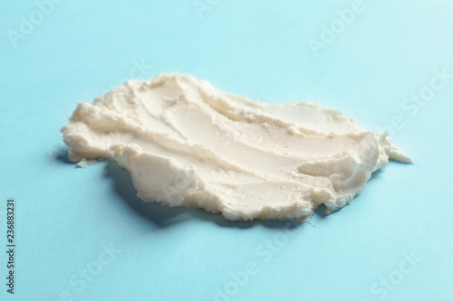 Smear of tasty cream cheese on color background