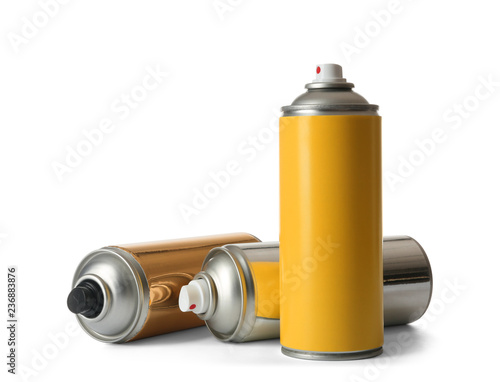 Cans of different spray paints on white background photo