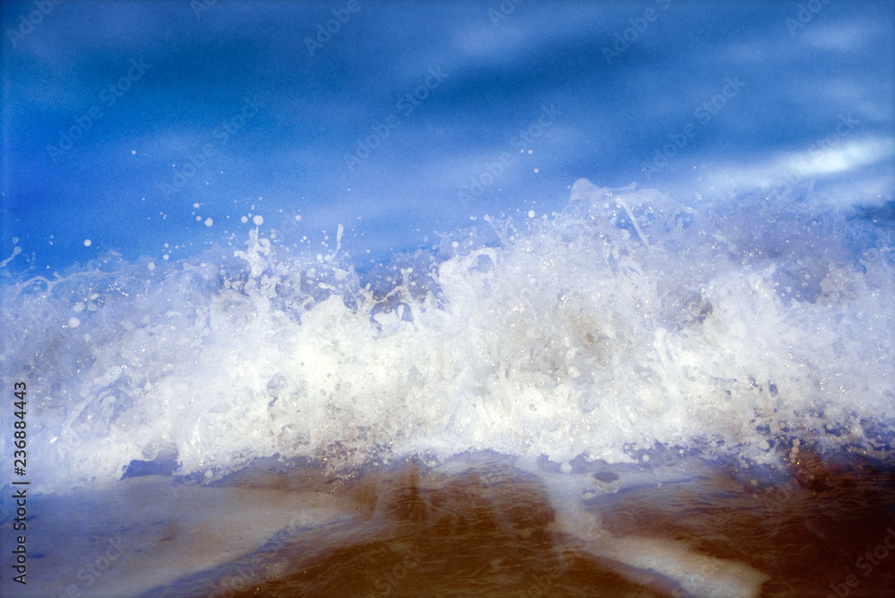 Obraz premium Close-up of incoming whitewater wave against blue sky