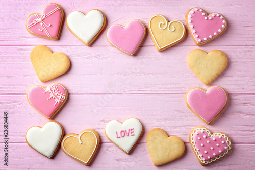 Flat lay composition with heart shaped cookies and space for text on wooden background. Valentine's day treat