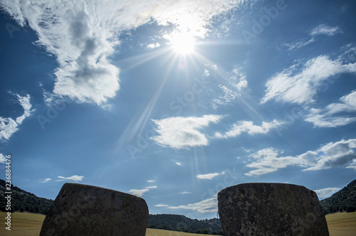 Sun descending between entry orthostates of Magacela Dolmen, Spain photo