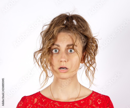 Foto .A young disheveled woman with big eyes looks frightened. Concept emotion fear o