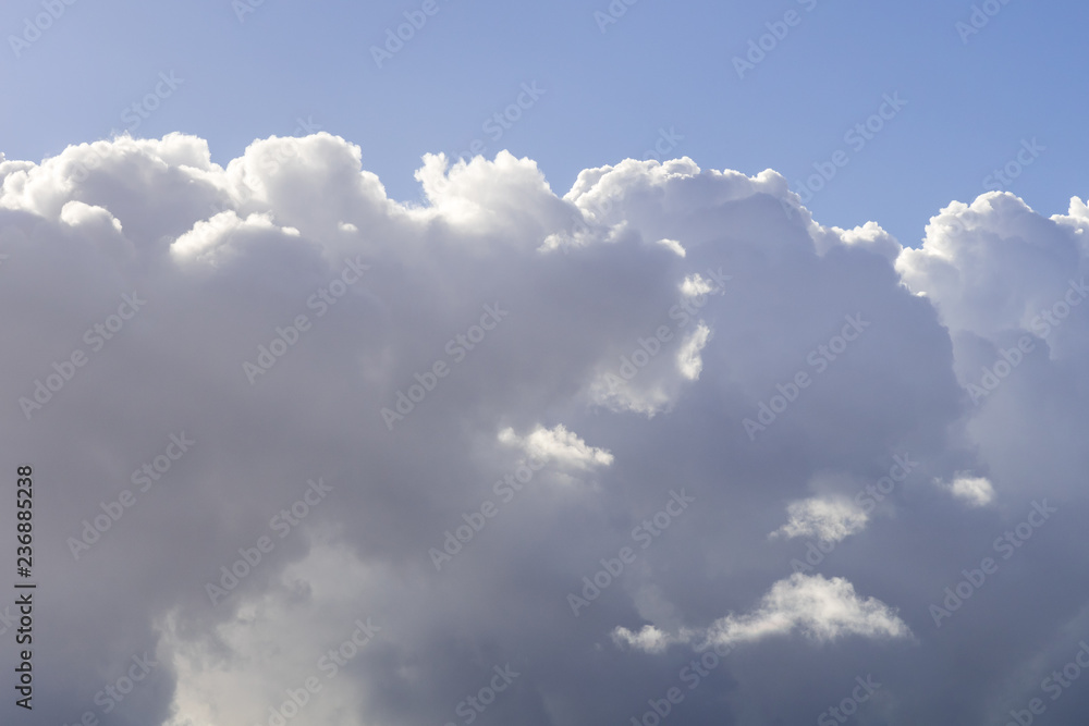 Dramatic cloudy sky, white and gray clouds moving across the sky with blue sky above, nature background Dramatic cloudy sky, white and gray clouds moving across the sky with blue sky above, nature background