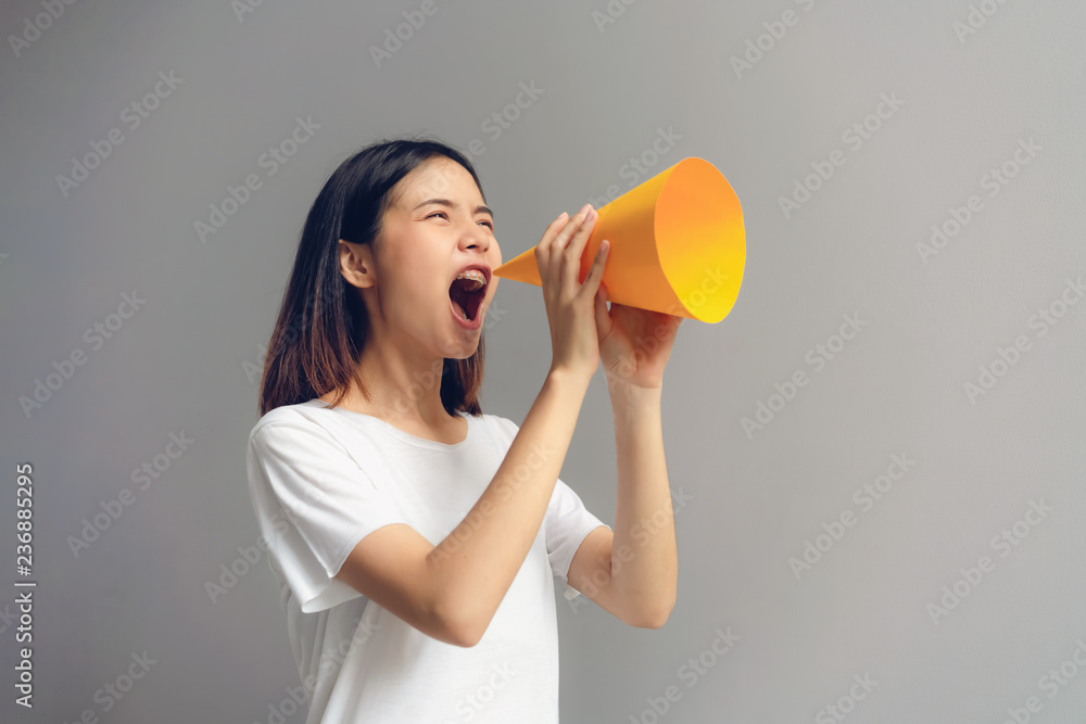 Young woman holding paper megaphone and yelling into. Young woman holding paper megaphone and yelling into.
