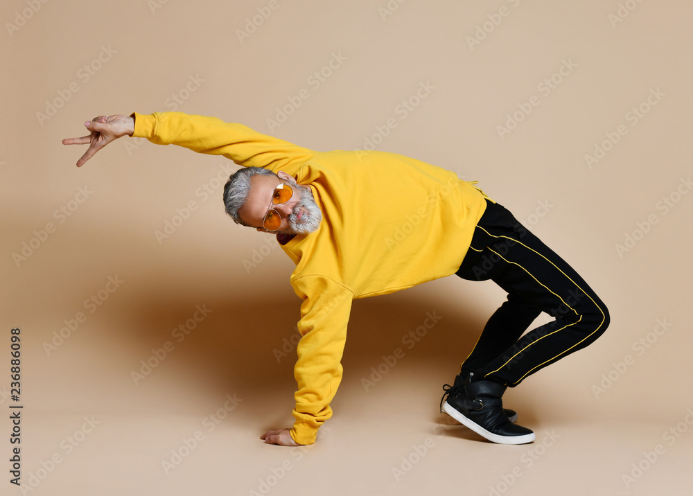 Happy senior millionaire man dancing in yellow sunglasses stylish fashionable men senior