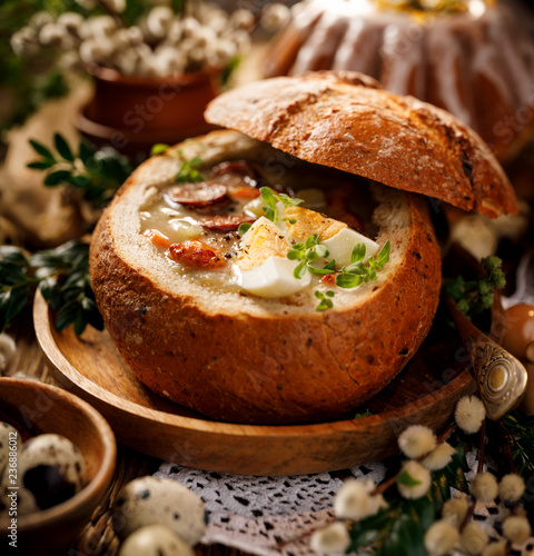 Easter polish sour soup (Żurek) made of rye flour with smoked sausage and eggs served in bread bowl. Traditional polish  Easter dish