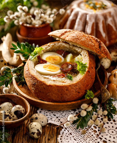 The Sour soup (Żurek) made of rye flour with sausage and eggs served in bread bowl. Traditional polish sour rye soup, popular Easter dish