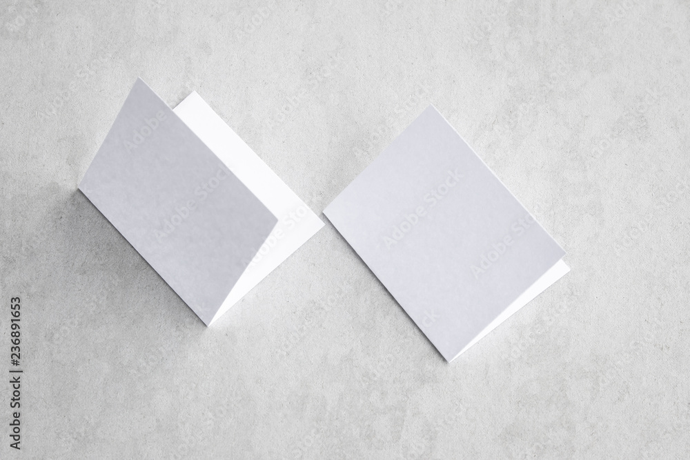 Fototapeta premium Blank portrait mock-up paper. brochure magazine isolated on gray, changeable background / white paper isolated on gray cement backdrop.