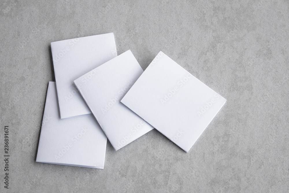 Blank portrait mock-up paper. brochure magazine isolated on gray, changeable background / white paper isolated on gray cement backdrop. Blank portrait mock-up paper. brochure magazine isolated on gray, changeable background / white paper isolated on gray cement backdrop.