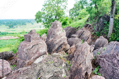 top view of circular shaped big rock at top of a hills looking good with greenery forest.