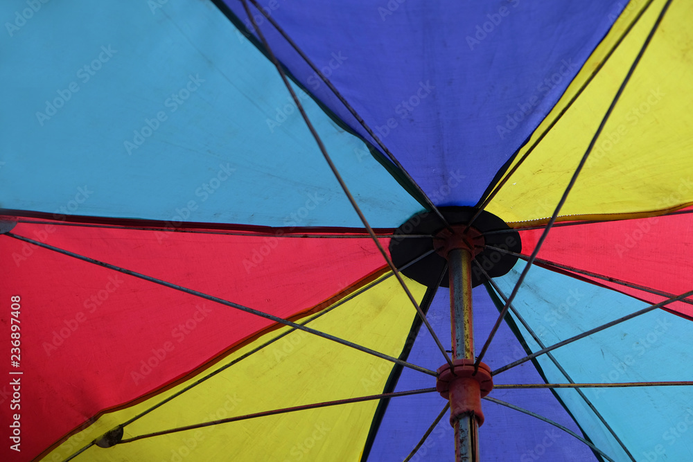 Closeup of under colorful umbrella beach on sunny day