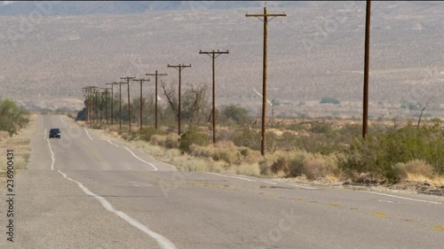 Car driving down hot desert road