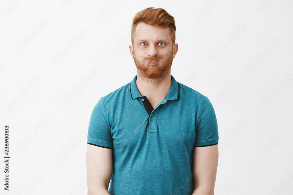 Puff up like balloon. Friendly playful and carefree redhead mature caucasian guy with bristle holding breath inside mouth and pouting with childish expression and smile, fooling around over grey wall Puff up like balloon. Friendly playful and carefree redhead mature caucasian guy with bristle holding breath inside mouth and pouting with childish expression and smile, fooling around over grey wall