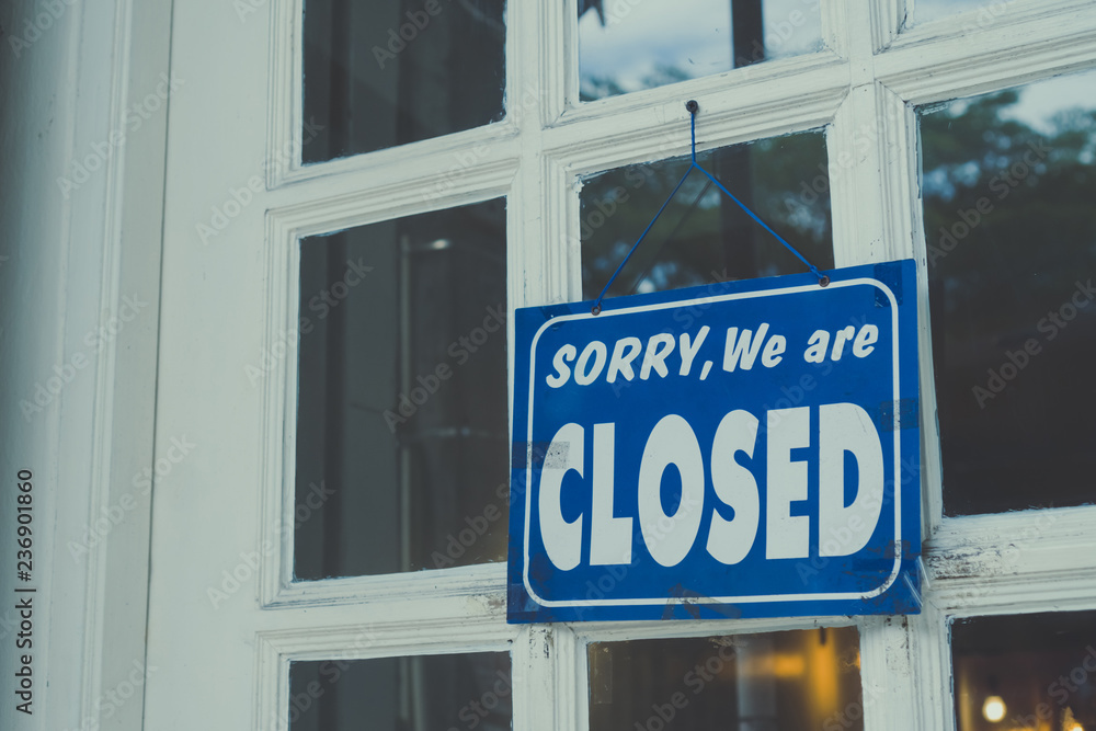 Naklejka premium Sorry we are closed sign hang on door of business shop.