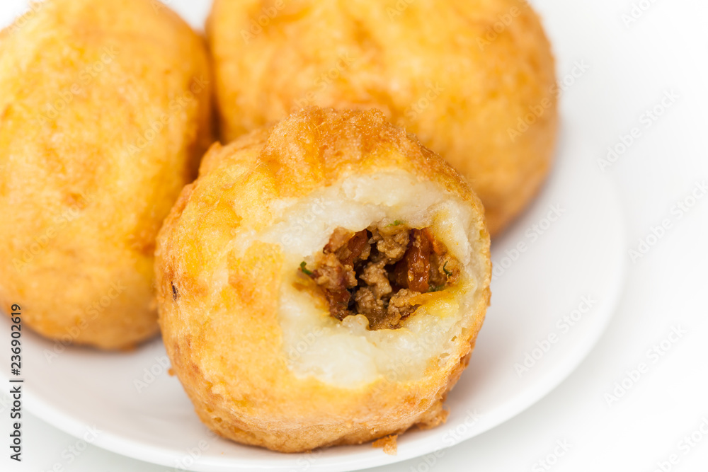 Preparation steps of traditional Colombian dish called stuffed potatoes : Ready stuffed potatoes served in a white ceramic dish isolated on white background Preparation steps of traditional Colombian dish called stuffed potatoes : Ready stuffed potatoes served in a white ceramic dish isolated on white background
