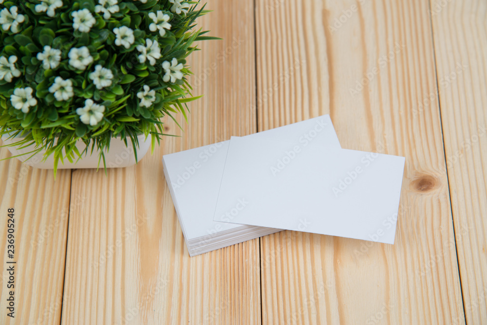 Blank business cards and little decorative tree in white vase on wooden working table with copy space for add text ID. and logo, business company concept. Blank business cards and little decorative tree in white vase on wooden working table with copy space for add text ID. and logo, business company concept.