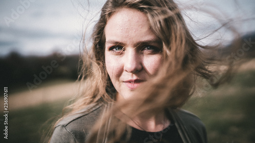 Wind blows young woman's long hair
