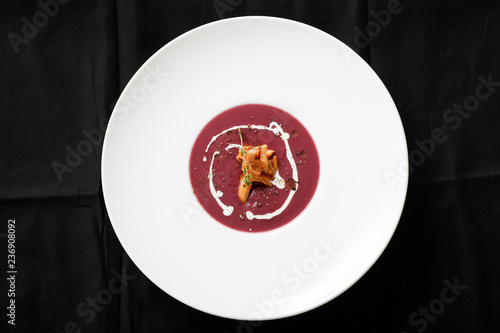 Top view of red cream soup with squid dish