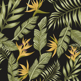 Green palm leaves yellow tropical flowers seamless black background