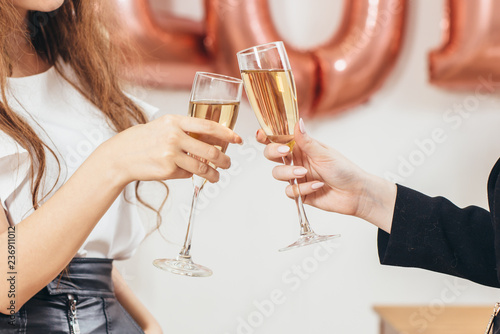 Canvas Print Hands close up. Two women clink glasses during holiday