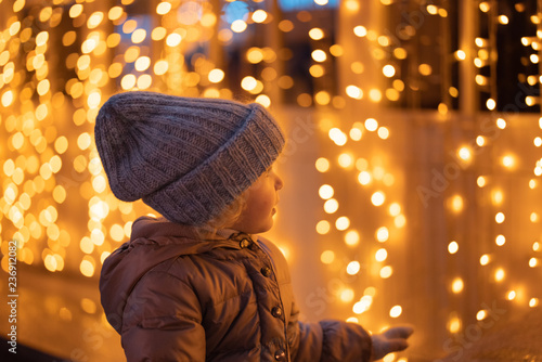 portrait of happy girl in winter evenings on background of Christmas lights