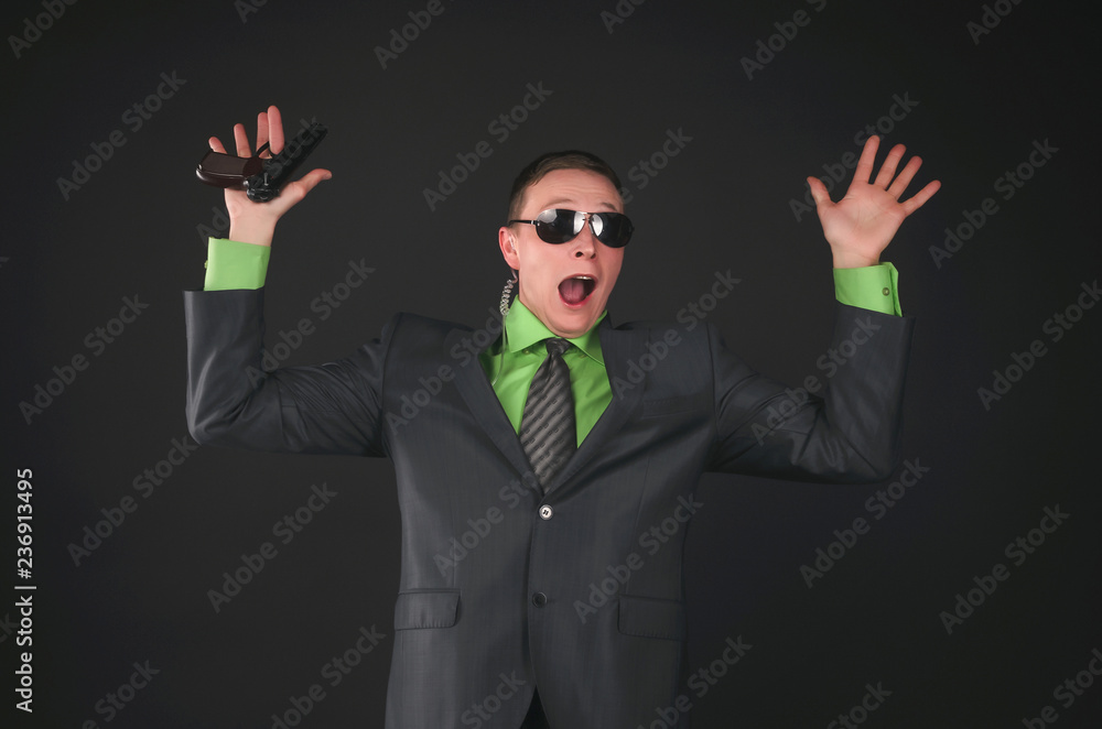 Scared security agent is surrender and holding his hand with a gun raised up isolated on black background. Scared security agent is surrender and holding his hand with a gun raised up isolated on black background.