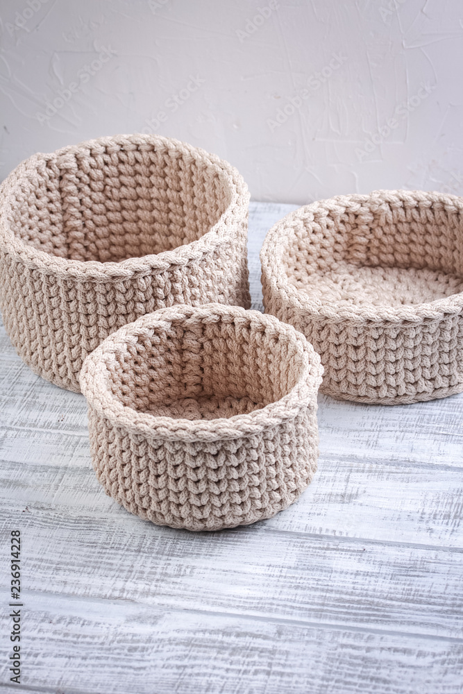 Fototapeta premium Knitted baskets of cord on a white background