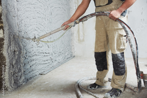 plastering the interior wall with an automatic spraying plaster pump machine photo