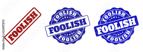 FOOLISH grunge stamp seals in red and blue colors. Vector FOOLISH overlays with grunge effect. Graphic elements are rounded rectangles, rosettes, circles and text labels.