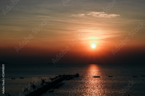 Sunset at the bridge by the sea with a boat surrounded.