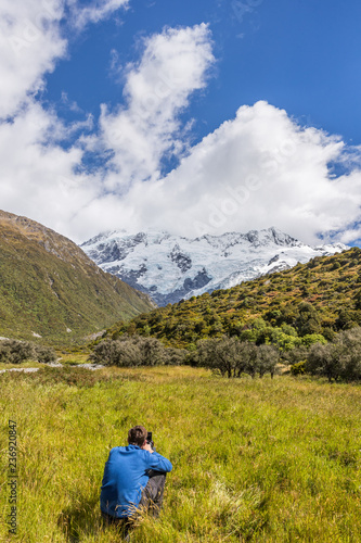 Nature landscape photography photographer shooting in New Zealand. Beautiful travel destination tourism hiker taking pictures on Routeburn track, famous tramping trail in south island.